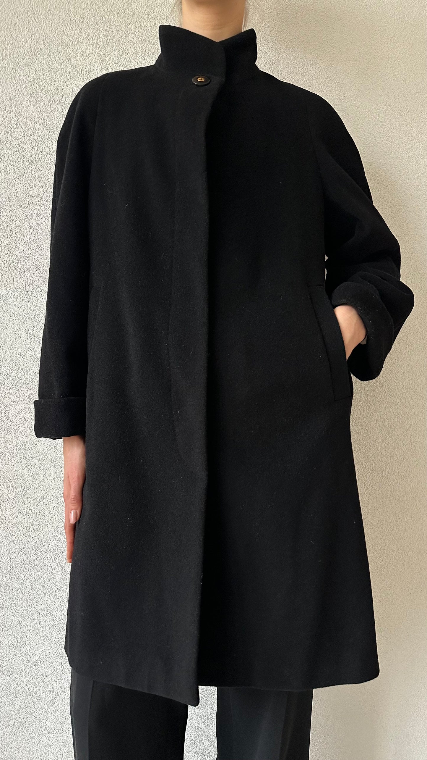 black wool coat with high collar and statement top button