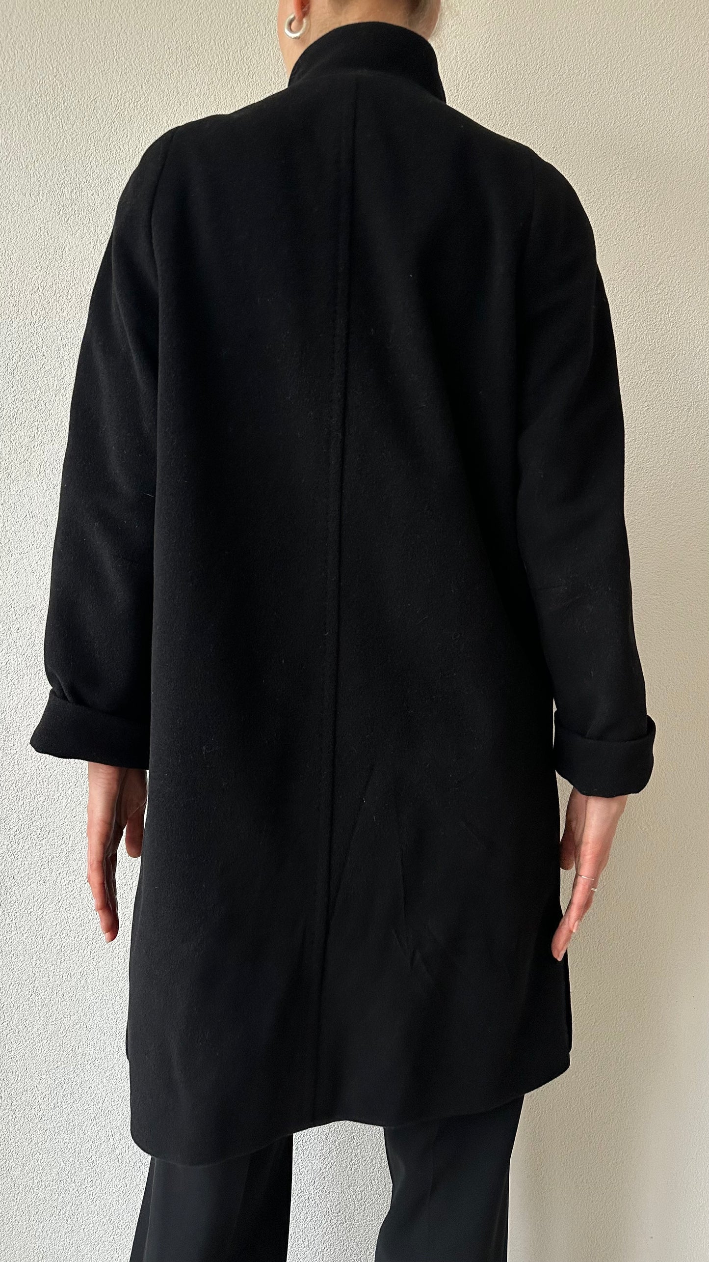 black wool coat with high collar and statement top button